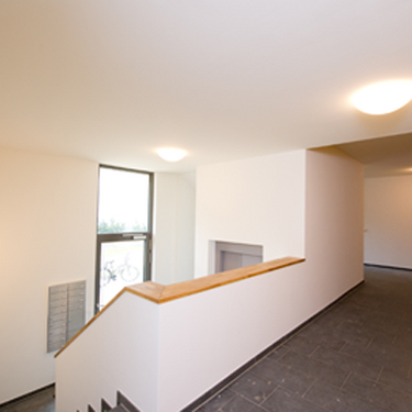 Ein moderner Hausflur in einem Neubau mit heller Beleuchtung und schlichtem Design.