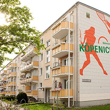 Ein Mehrfamilienhaus in Köpenick Nord zeigt ein großes Wandbild mit Sportmotiven an der Fassade.